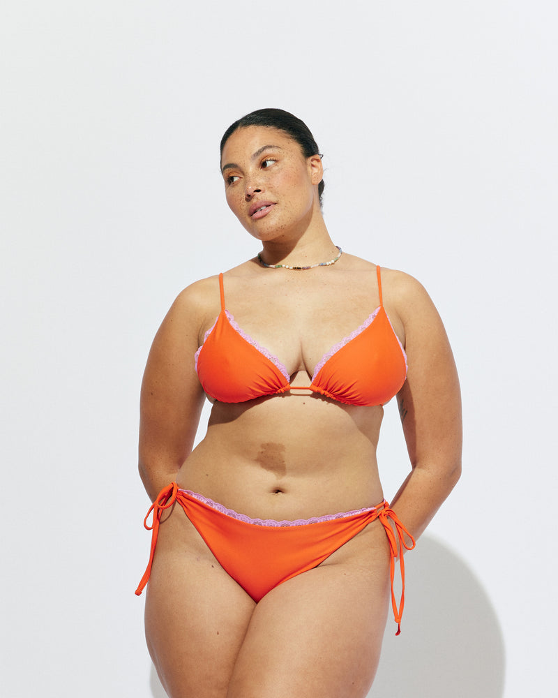 WYLIE TRIANGLE BIKINI TOP VERMILLION | Named after the Wylie's Baths in Sydney, this vermillion bikini top is designed in a classic triangle style with a vibrant pink lace trim. With adjustable ties for a flexible fit, make it a set with the Wylie Tie-side Bikini...