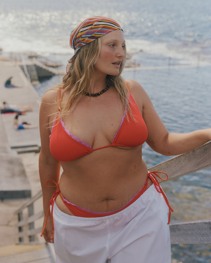 WYLIE TIE-SIDE BIKINI BOTTOM VERMILLION | Named after the Wylie's Baths in Sydney, these vermillion bikini bottoms are designed with a cheeky cut and adjustable side ties. Featuring a bright pink contrast lace trim, make it a matching set with the Wylie Triangle Bikini Top or...