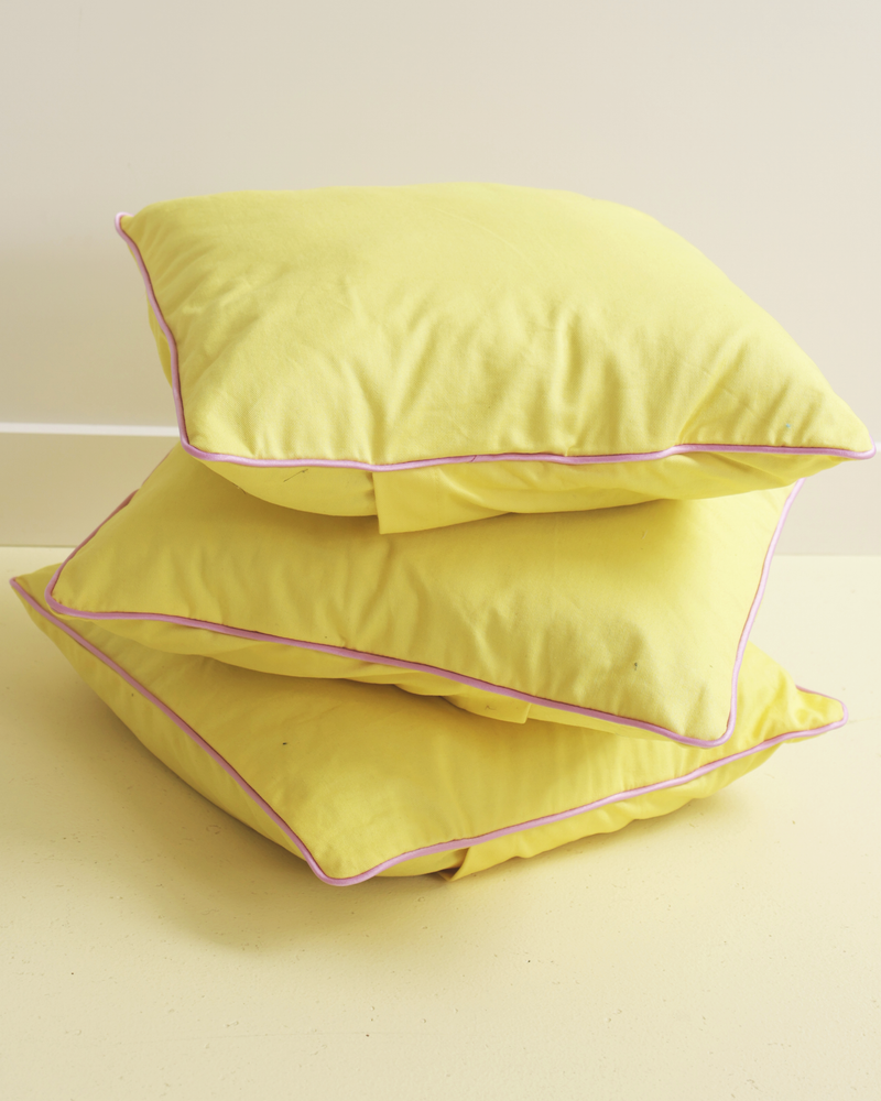 PIPE DREAM RECYCLED CUSHION SUNSHINE PINK | Our very own RUBY cushions have arrived! Medium-sized decor cushion designed in yellow cotton with a feature pink piping around the edge. The perfect way to bring some colour into...