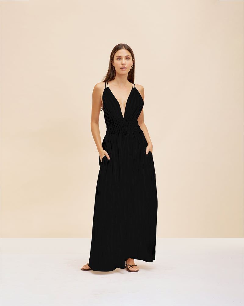 HERO MAXI DRESS BLACK | Double strap maxi dress with a plunge neckline, shirred waist detail and side split in a black cotton. The shirring at the waist accentuates the full skirt.