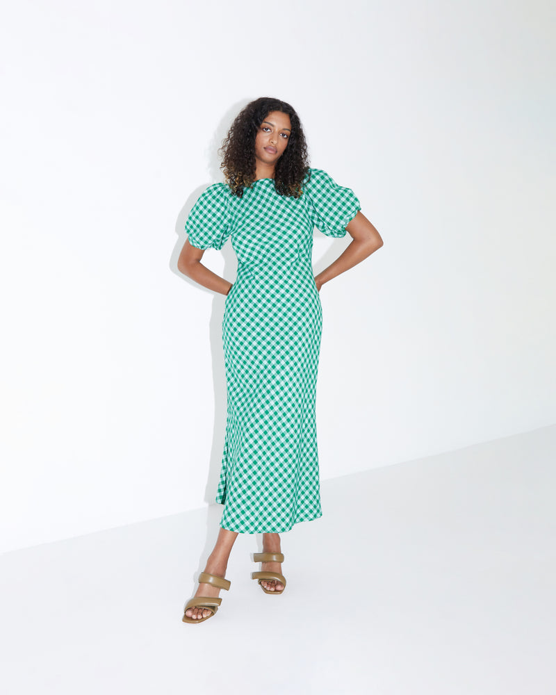 HEIDI GINGHAM DRESS GREEN GINGHAM | Bias cut midi dress with twisted puff sleeves and a keyhole opening with tie closure at the back neck. Cut from a tonal green gingham, this piece is designed to...