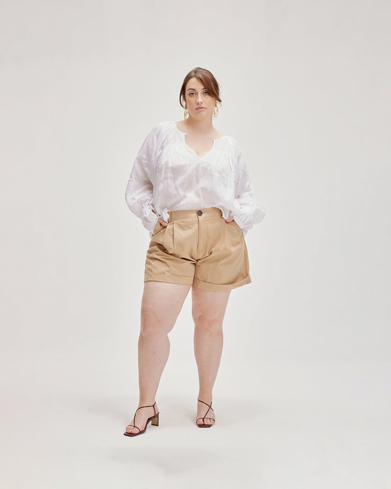 RAFFIA SHORT CAMEL | Chino style A-line short designed in a mid-weight tan cotton drill. The front tucks and rolled hem give these shorts a vintage look.