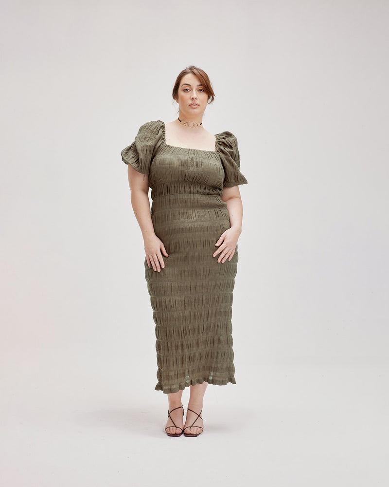 MIRELLA PUFF SLEEVE DRESS OLIVE | Fitted maxi dress with a square neckline, short elasticated puff sleeves and a slit at the centre back in an olive shade. The voluminous sleeves make this silhouette a stand...