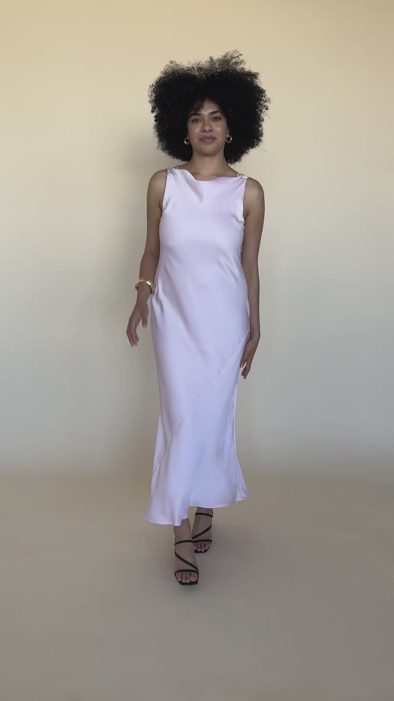 FIREBIRD COWL GOWN FESTIVAL BLOOM | Sleeveless midi dress crafted in luxe 'festival bloom' pink satin. Features a minimal silhouette with a cowl back detail and a tie to cinch in the waist.
