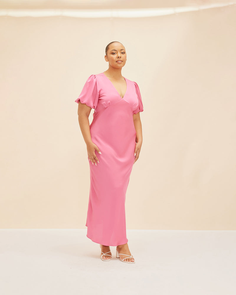 UMA SATIN DRESS HOT PINK | Bias cut satin maxi dress with tie closure and a V-neck front and back. Back in a new hot pink satin, with elasticated puff sleeves and ruched sleeve detailing under...
